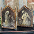 A pair of gothic Memento Mori 16th Century Italy shaped like religious saint panels, featuring skeletal figures and aged gold-brown frames on a dark background.