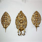 Three ornate antique gold wall sconces with intricate floral and scrollwork designs, mounted on a plain white wall.