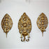 Three ornate antique gold wall sconces with intricate floral and scrollwork designs, mounted on a plain white wall.