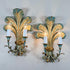 A pair of antique Italian wooden ornate wall sconces with leaf-like sculptural forms in distressed teal, gold, and brown tones, each holding a candle-style bulb.