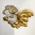 An antique gilded cherub wall sconce featuring a painted face with distressed gray and white tones, detailed with ornate gold wings and scrollwork.