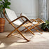 Two mid-century modern folding lounge chairs with curved bamboo frames and white canvas seats, styled in a sunlit room with plants and a textured rug.