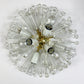 A mid-century modern flush mount ceiling light fixture featuring a central brass fixture with multiple clear glass rods ending in faceted crystal globes, with two additional white and clear glass shades hanging below.