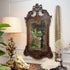 An ornate, antique George II Style Mirror late 19th Century rectangular wall mirror with a dark carved wood frame hangs on a white paneled wall above a console table styled with a brass lamp, a deer skull, white coral, and a tall spiky decorative object.