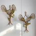 A pair of Henri Fernandez Signed Agate and Brass Wall Lights mounted on a white wall. Each sconce features three petals made from agate slices with gold-toned fronds and leaves, attached to copper-toned stems.
