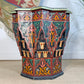 A decorative octagonal Moroccan Star wooden side table with intricate hand-painted Moroccan-style patterns in red, green, orange, and black, set against a neutral indoor background.