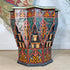 A decorative octagonal Moroccan Star wooden side table with intricate hand-painted Moroccan-style patterns in red, green, orange, and black, set against a neutral indoor background.