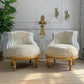 Pair of ornate antique French armchairs with gold frames in a room with decorative elements.