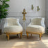 Pair of ornate antique French armchairs with gold frames in a room with decorative elements.