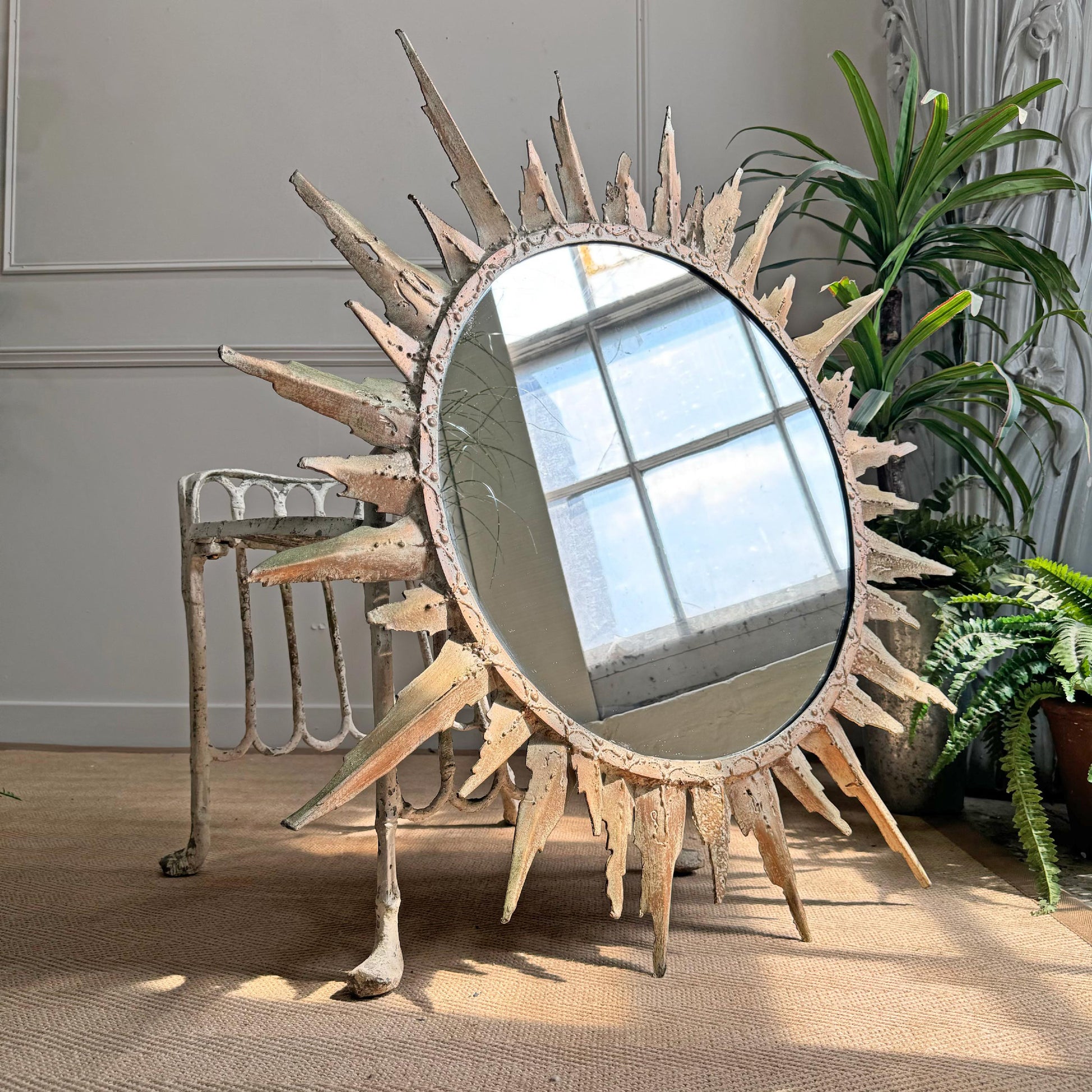 A 20th century hand crafted French metal sunburst mirror, in the brutalist fashion, of incredible large proportions with welded decorative flourishes, finished in an off white 