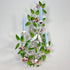 A decorative wall-mounted candelabra with three light blue candle sleeves, white metal branches, green leaves, pink roses, and two small white birds, shown against a plain light gray wall.