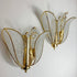 A pair of vintage gold butterfly wall sconces with textured clear crystal wings, mounted on a plain white wall.