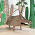 A Woven Dream Spirit Wild Pig, Papua New Guinea in brown woven grass displayed on a beige floor with decorative green and beige cactus plants in the background.